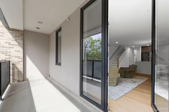 a view of a hallway with wooden floor and a living room