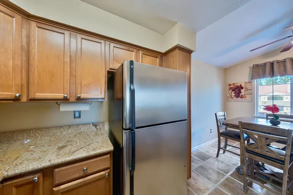 a kitchen with granite countertop a refrigerator and a stove top oven