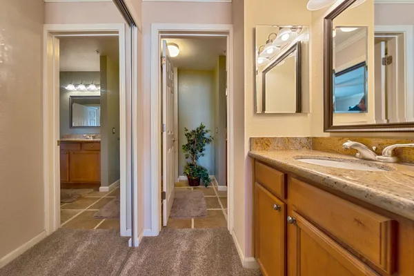 a bathroom with a granite countertop sink and a mirror