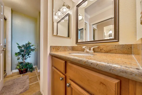 a bathroom with a granite countertop sink and a mirror