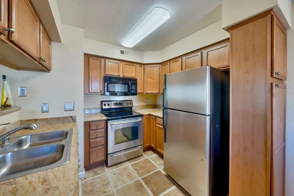 a kitchen with stainless steel appliances granite countertop a refrigerator stove and sink