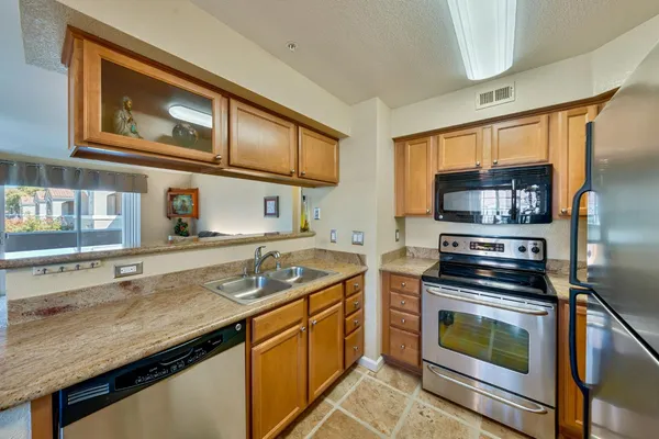 a kitchen with stainless steel appliances granite countertop a stove and a sink