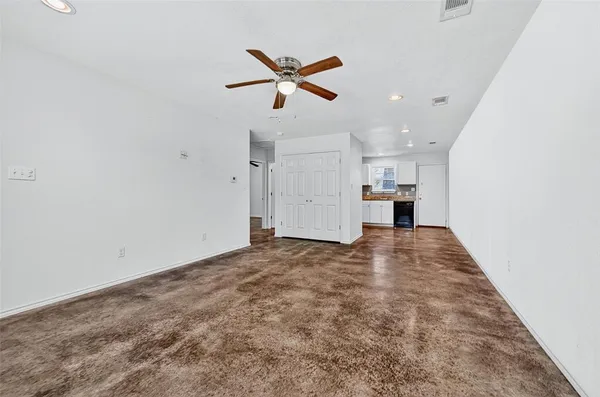 a view of empty room with wooden floor and ceiling fan