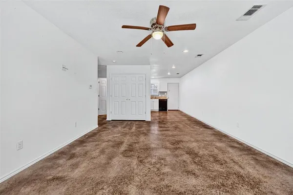 a view of empty room with wooden floor and ceiling fan
