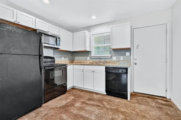 a kitchen with a stove a sink and a refrigerator