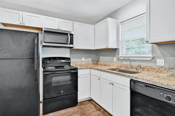 a kitchen with stainless steel appliances granite countertop a sink stove and microwave
