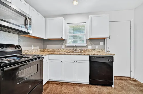 a kitchen with granite countertop cabinets stainless steel appliances and a sink