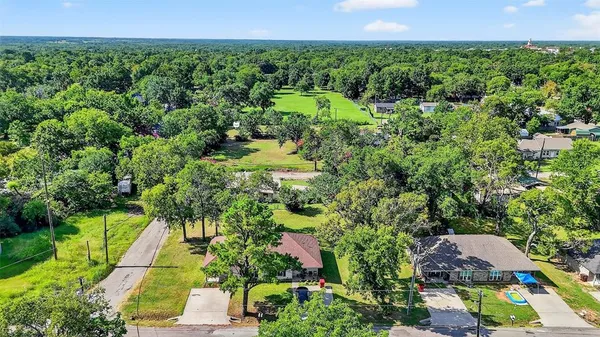 an aerial view of residential houses with outdoor space and trees