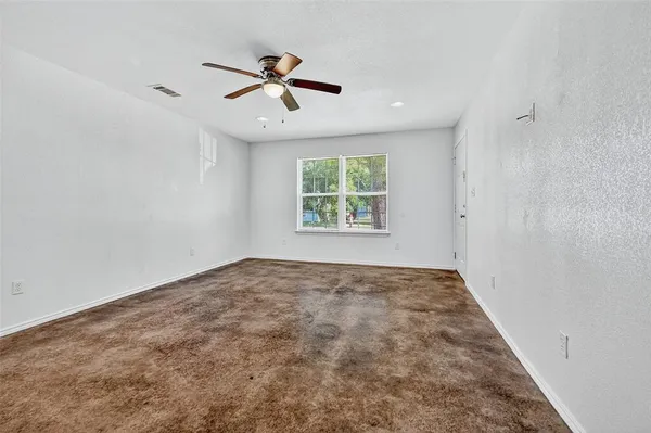 a view of empty room with ceiling fan