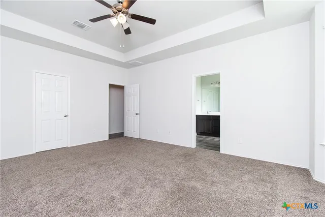 a view of an empty room with a ceiling fan