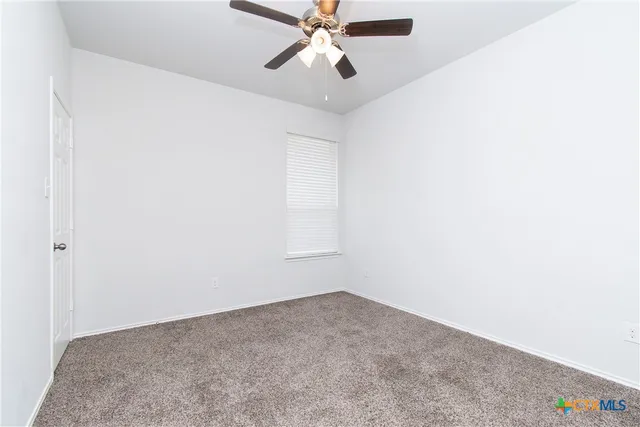 a view of a room with a ceiling fan and a window