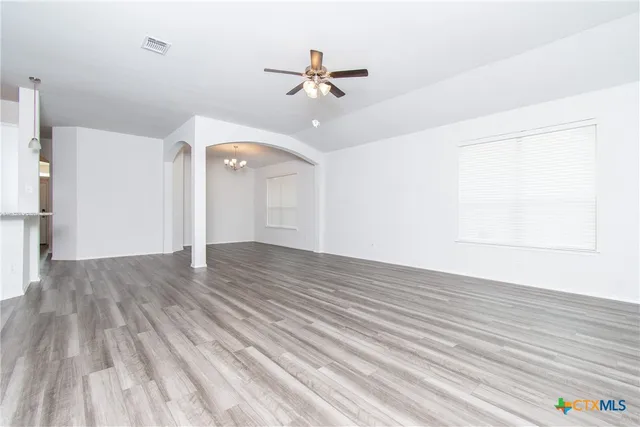 a view of a room with wooden floor and ceiling fan