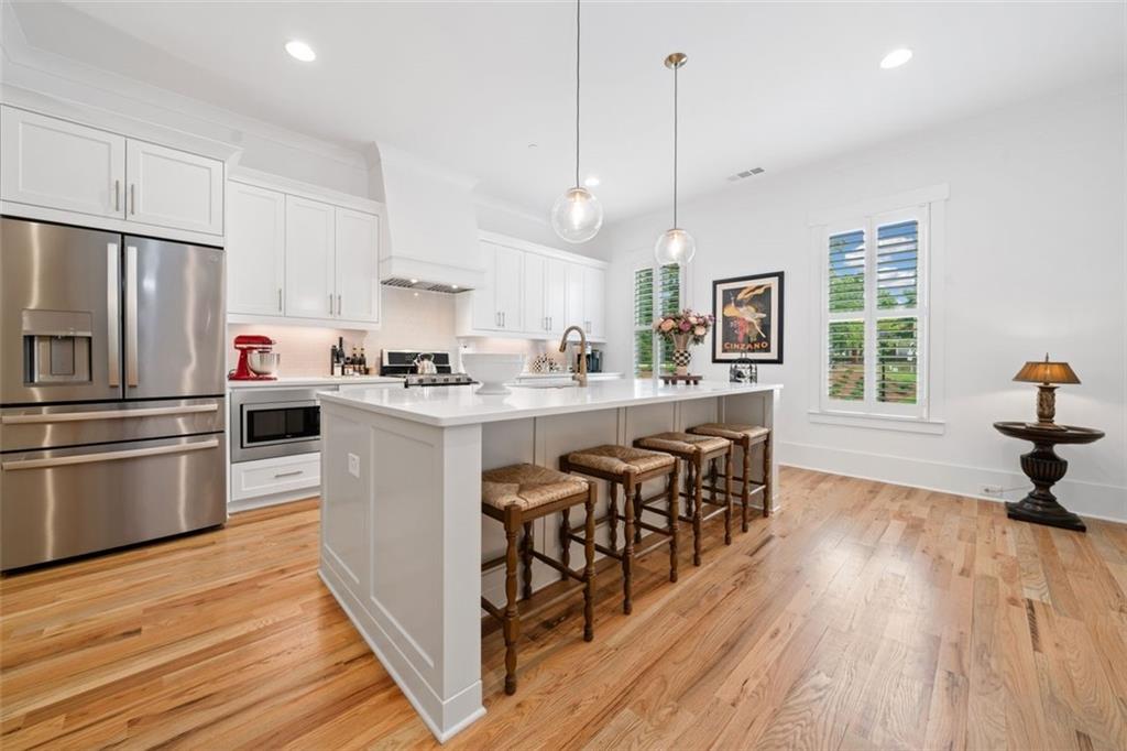 1045 Endeavour Court Marietta, GA 30064 - Photo 12 of 39 a kitchen with stainless steel appliances granite countertop a sink a stove a refrigerator and island with wooden floor