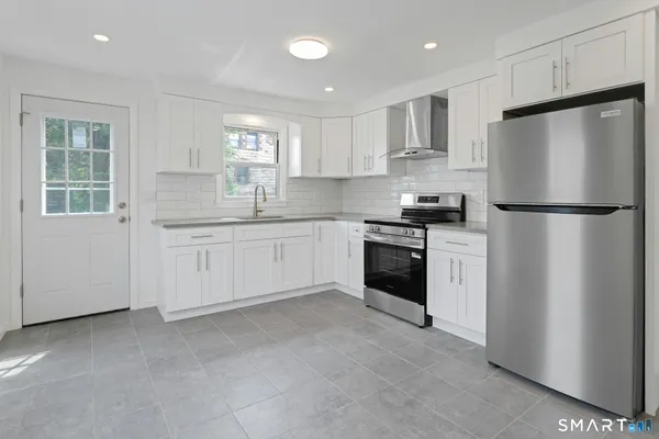 a kitchen with white cabinets and white appliances