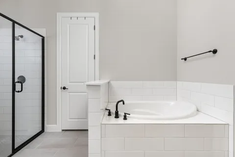 a bathroom with a tub sink double vanity and mirror
