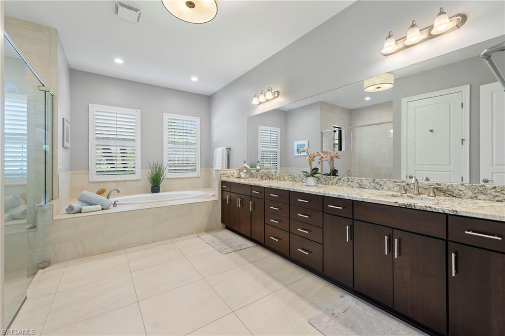 14517 Marsala Way Naples, FL 34109 - Photo 17 of 33 a spacious bathroom with a large tub sink and mirror