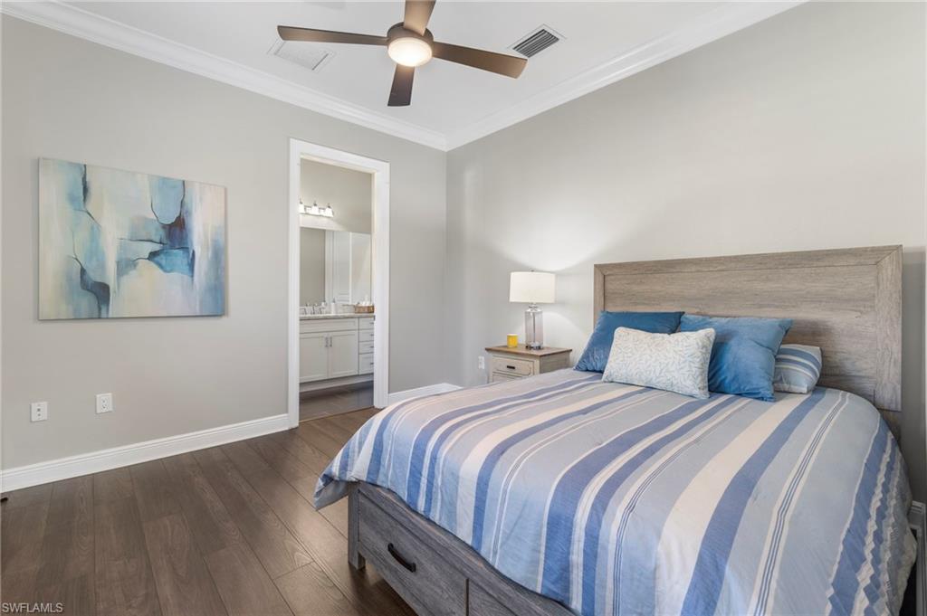 14517 Marsala Way Naples, FL 34109 - Photo 22 of 33 a bedroom with a large bed and a chandelier