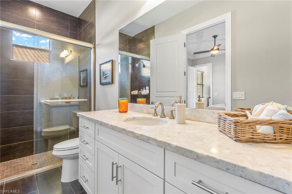 14517 Marsala Way Naples, FL 34109 - Photo 23 of 33 a bathroom with a granite countertop sink mirror vanity and toilet