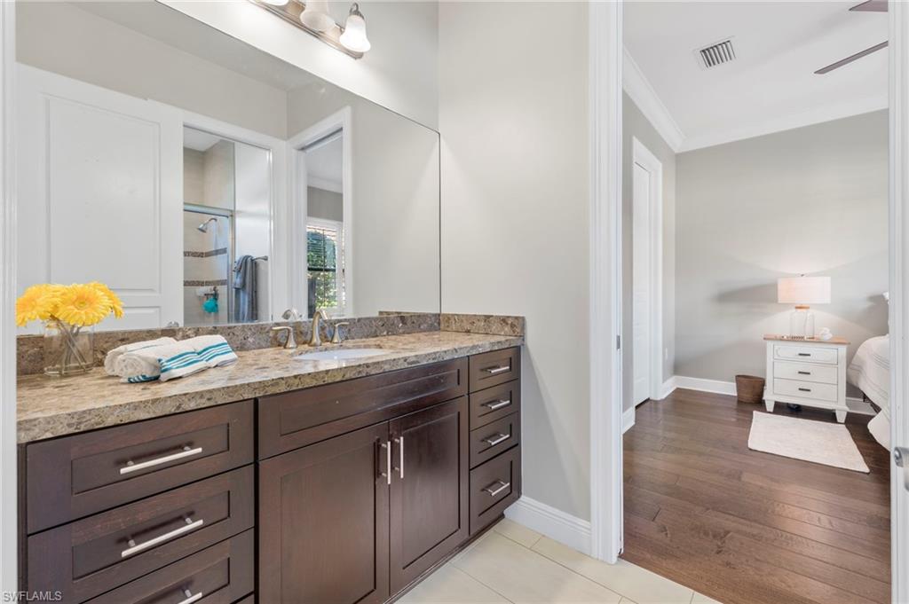 14517 Marsala Way Naples, FL 34109 - Photo 25 of 33 a en suite bathroom with a granite countertop sink and a mirror