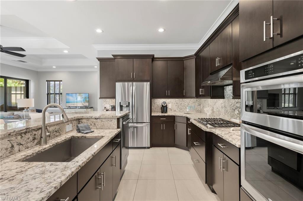 14517 Marsala Way Naples, FL 34109 - Photo 8 of 33 a kitchen with stainless steel appliances granite countertop a sink stove and refrigerator
