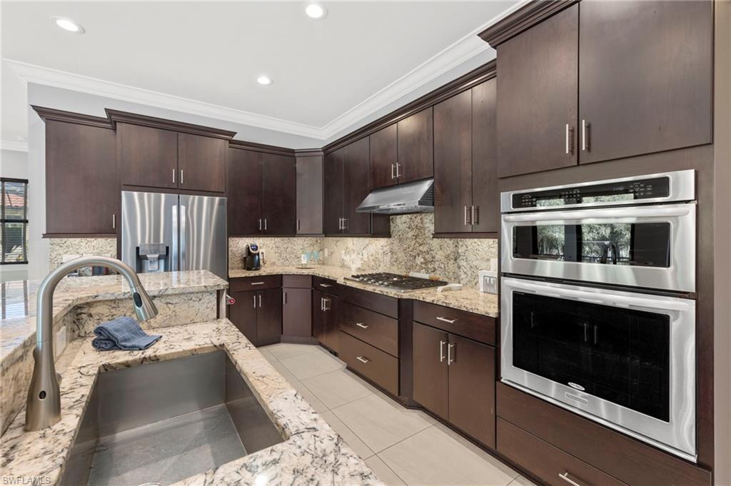 14517 Marsala Way Naples, FL 34109 - Photo 10 of 33 a kitchen with stainless steel appliances granite countertop a stove a sink and a microwave