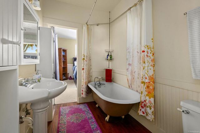 a bathroom with a sink a toilet and shower curtain
