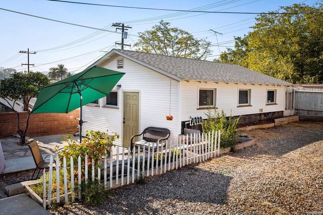 a view of a house with wooden fence next to a yard