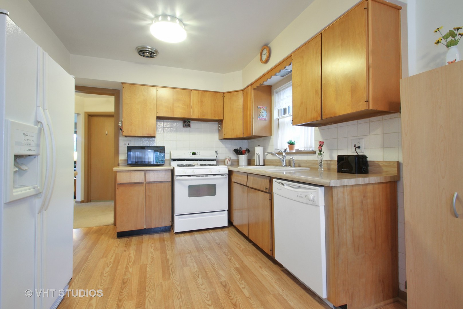8019 Wisner Street Niles, IL 60714 - Photo 4 of 11 a kitchen with white cabinets and white appliances