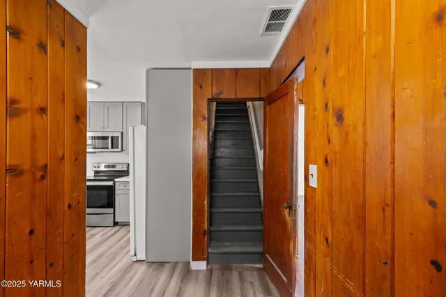 a view of hallway with wooden floor and stairs