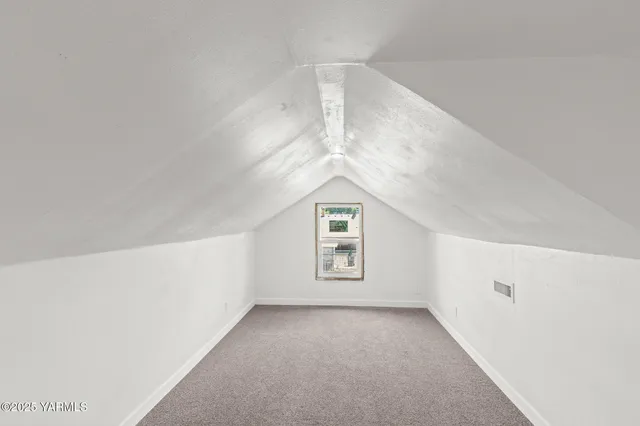 a view of a big room with windows and chandelier fan