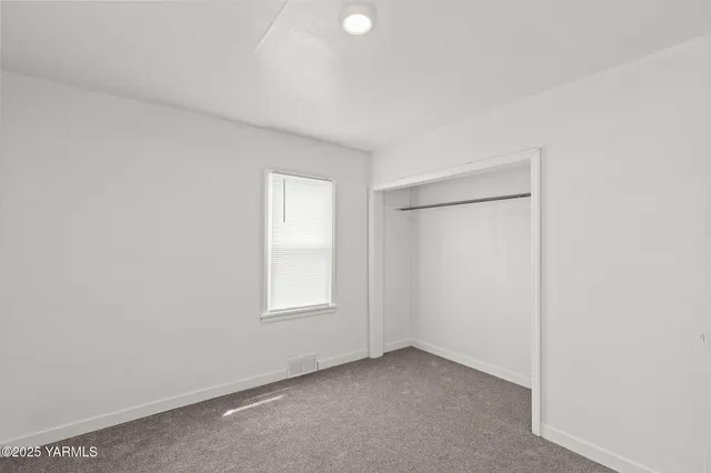an empty room with windows and closet