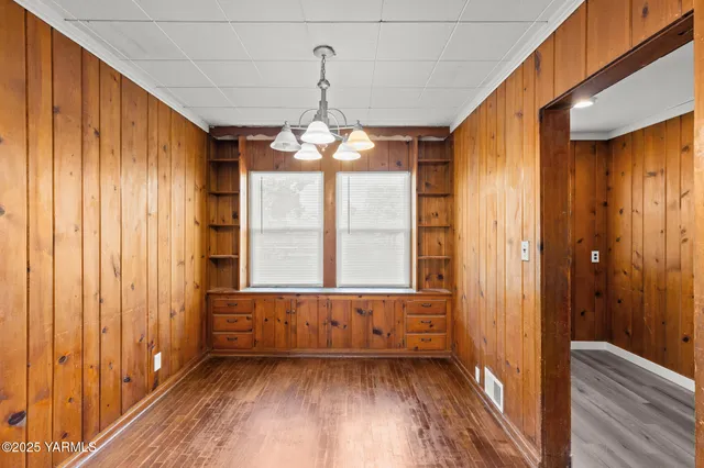 a view of a room with a large window and wooden floor