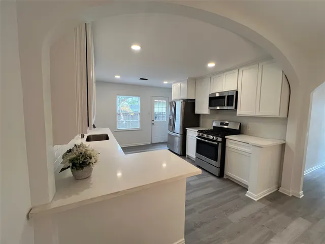 a kitchen with sink a microwave and cabinets