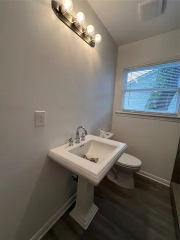 a bathroom with a sink a toilet and mirror