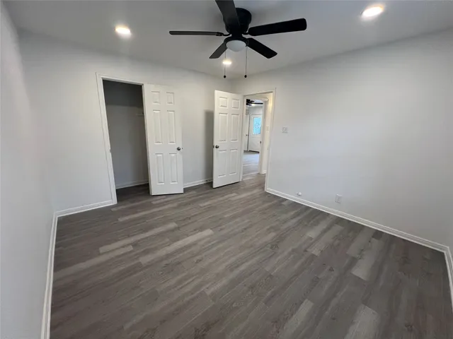 a view of a livingroom with wooden floor and a ceiling fan