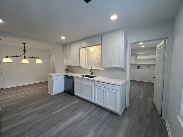 a kitchen with a sink cabinets and wooden floor