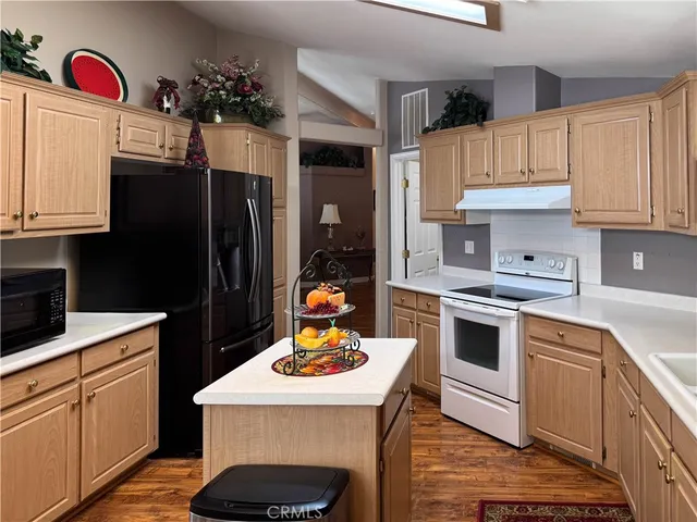 a kitchen with granite countertop a sink stove and refrigerator