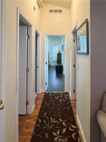 a bedroom with wooden floor closet and a bathroom