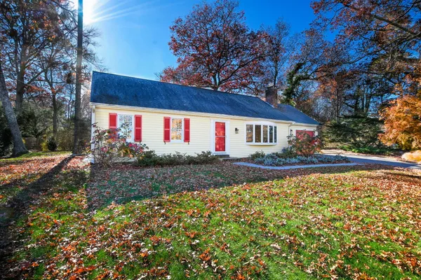 a front view of house with yard and trees around