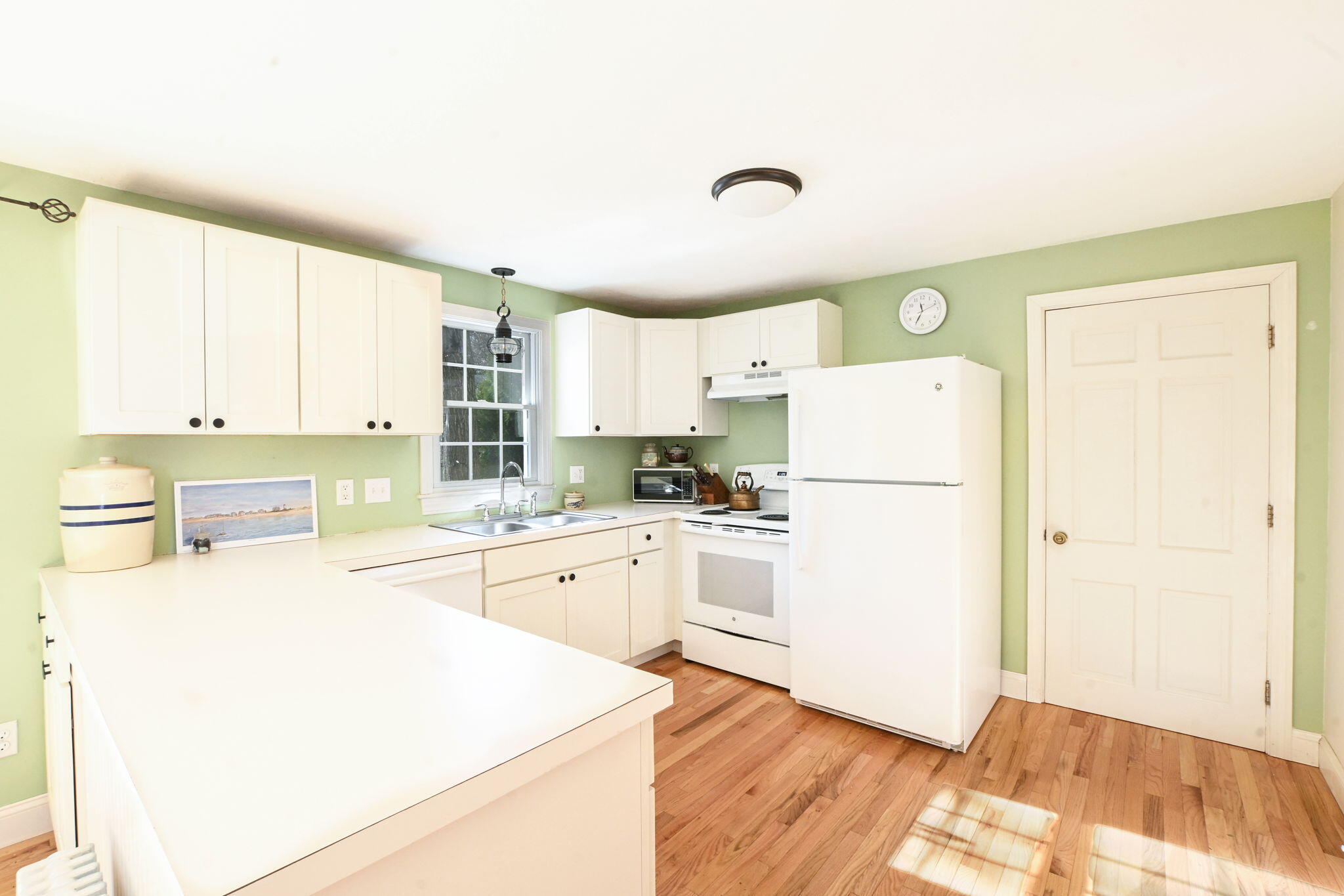 12 Crowell Road Sandwich, MA 02563 - Photo 23 of 49 a kitchen with a refrigerator a stove top oven and white cabinets