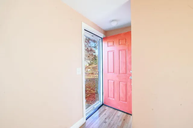 wooden floor fireplace and windows in an empty room