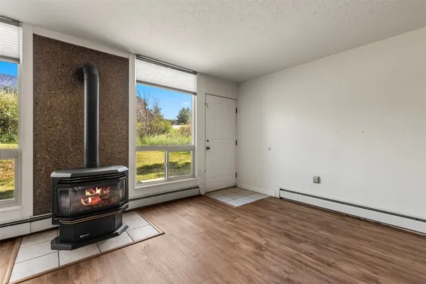 a view of an empty room with a fireplace and a window