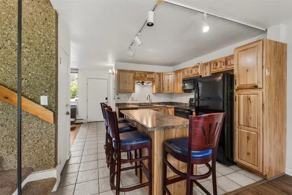 a dining room with stainless steel appliances a refrigerator a table and chairs