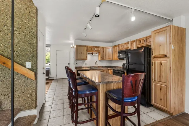 a dining room with stainless steel appliances a refrigerator a table and chairs