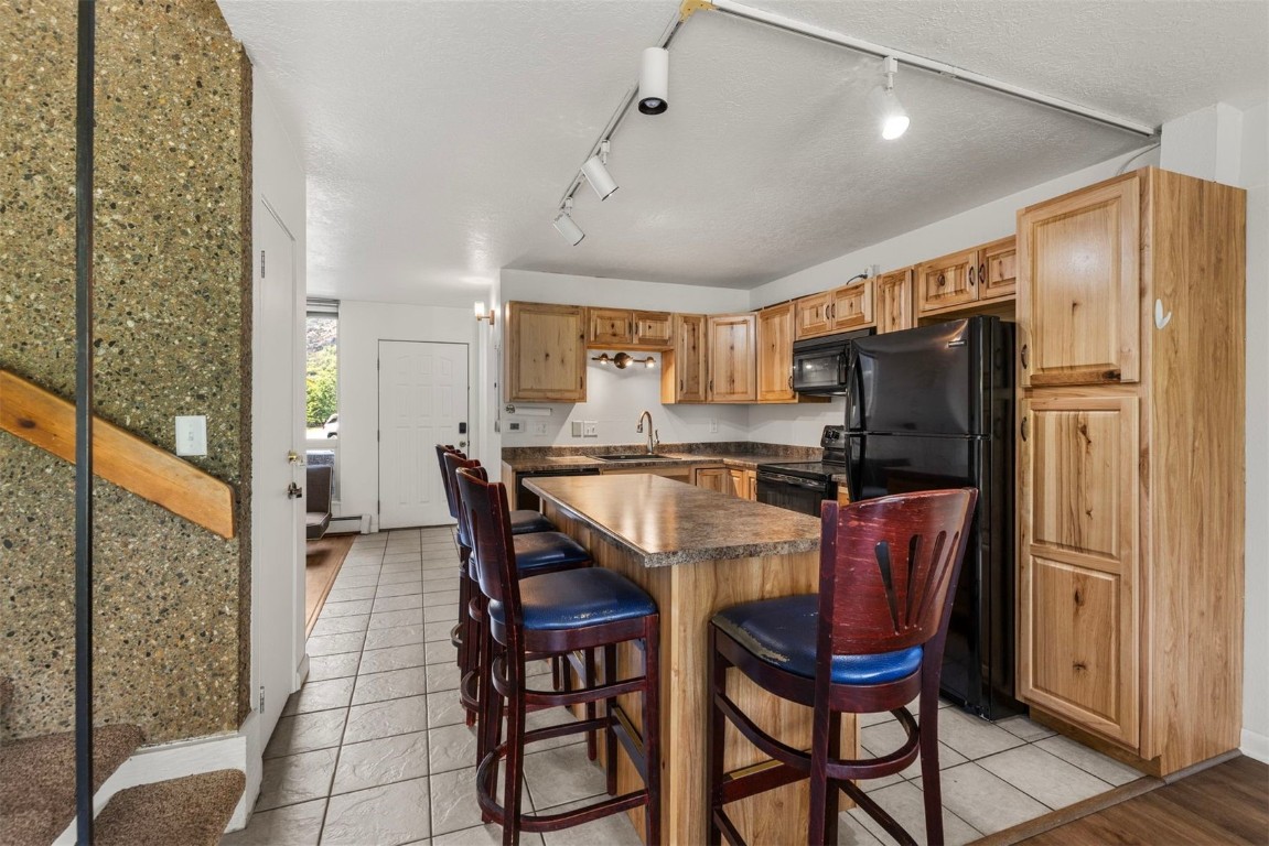 390 Straight Creek Drive, Unit 307 Dillon, CO 80435 - Photo 7 of 35 a dining room with stainless steel appliances a refrigerator a table and chairs