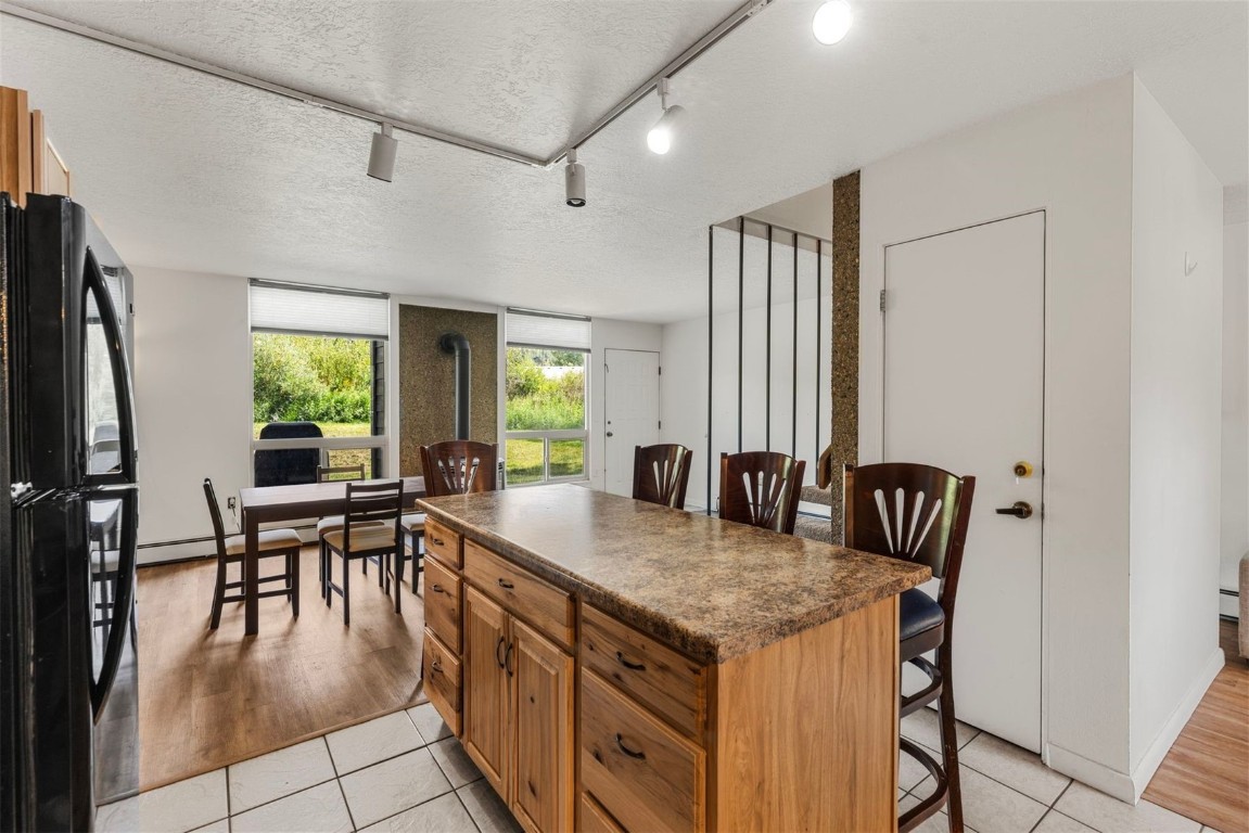 390 Straight Creek Drive, Unit 307 Dillon, CO 80435 - Photo 9 of 35 a dining hall with stainless steel appliances granite countertop a table chairs and a refrigerator