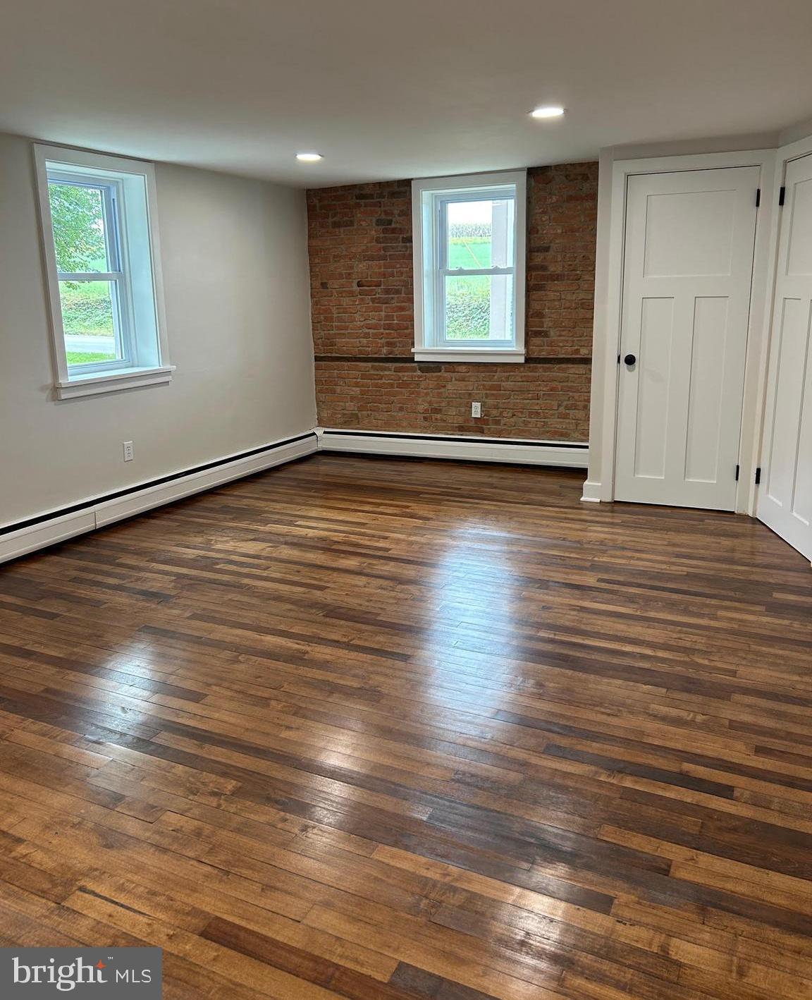 1355 Penn Grant Road, Unit 2 Strasburg, PA 17579 - Photo 5 of 13 an empty room with wooden floor and windows