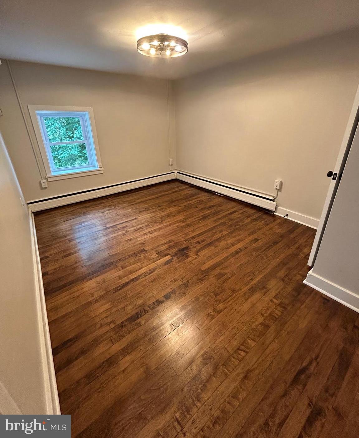 1355 Penn Grant Road, Unit 2 Strasburg, PA 17579 - Photo 8 of 13 an empty room with wooden floor and window