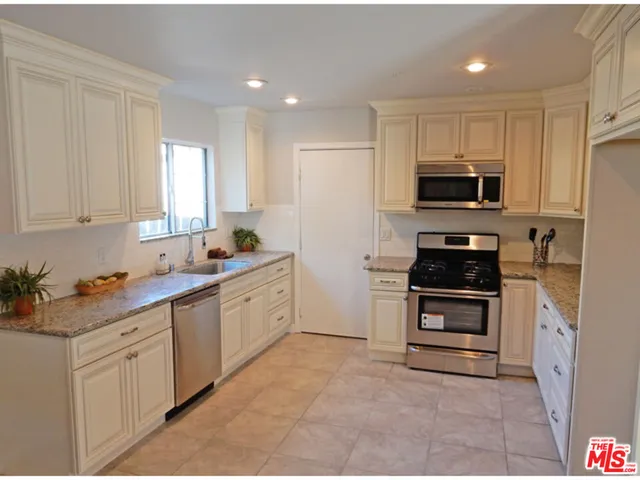 a kitchen with stainless steel appliances a stove sink microwave and cabinets