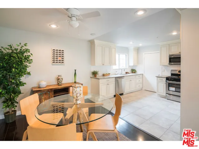 a room with stainless steel appliances kitchen island granite countertop a sink and cabinets